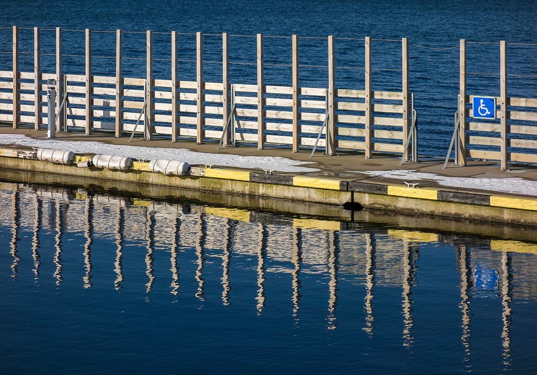 A wheelchair accessibility sign at a harbour pier.