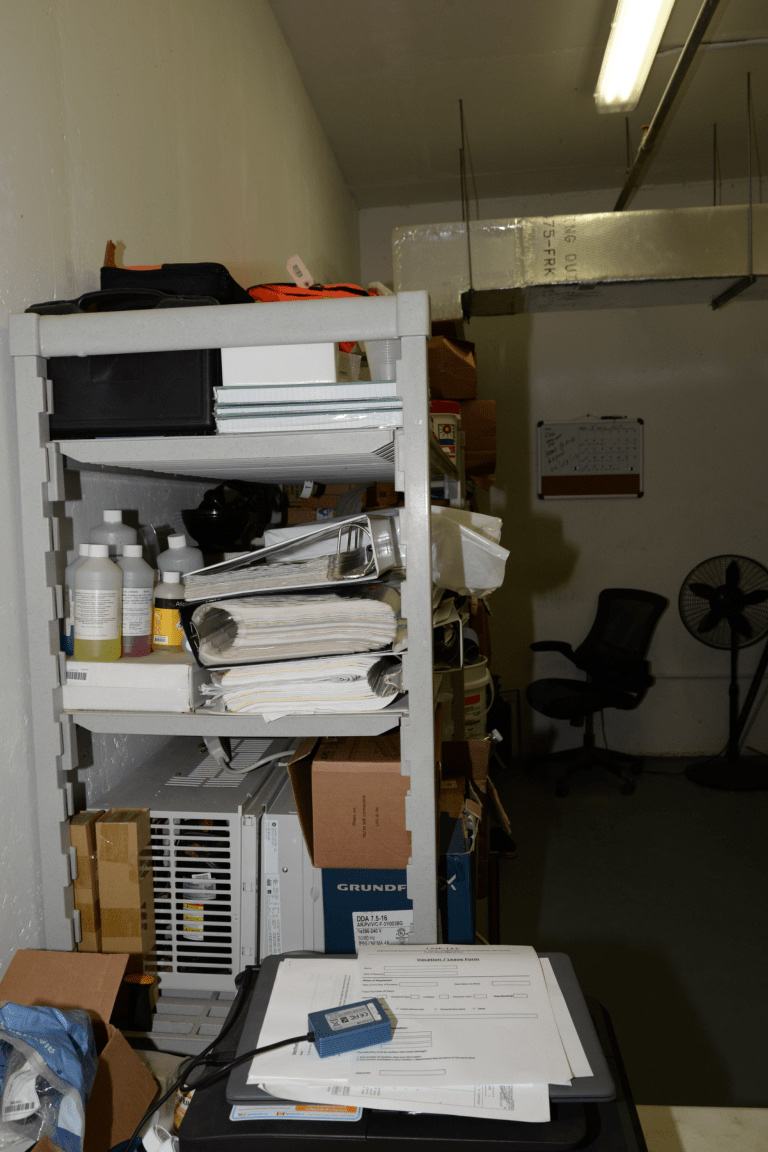 An office storage area with paperwork and a desk.